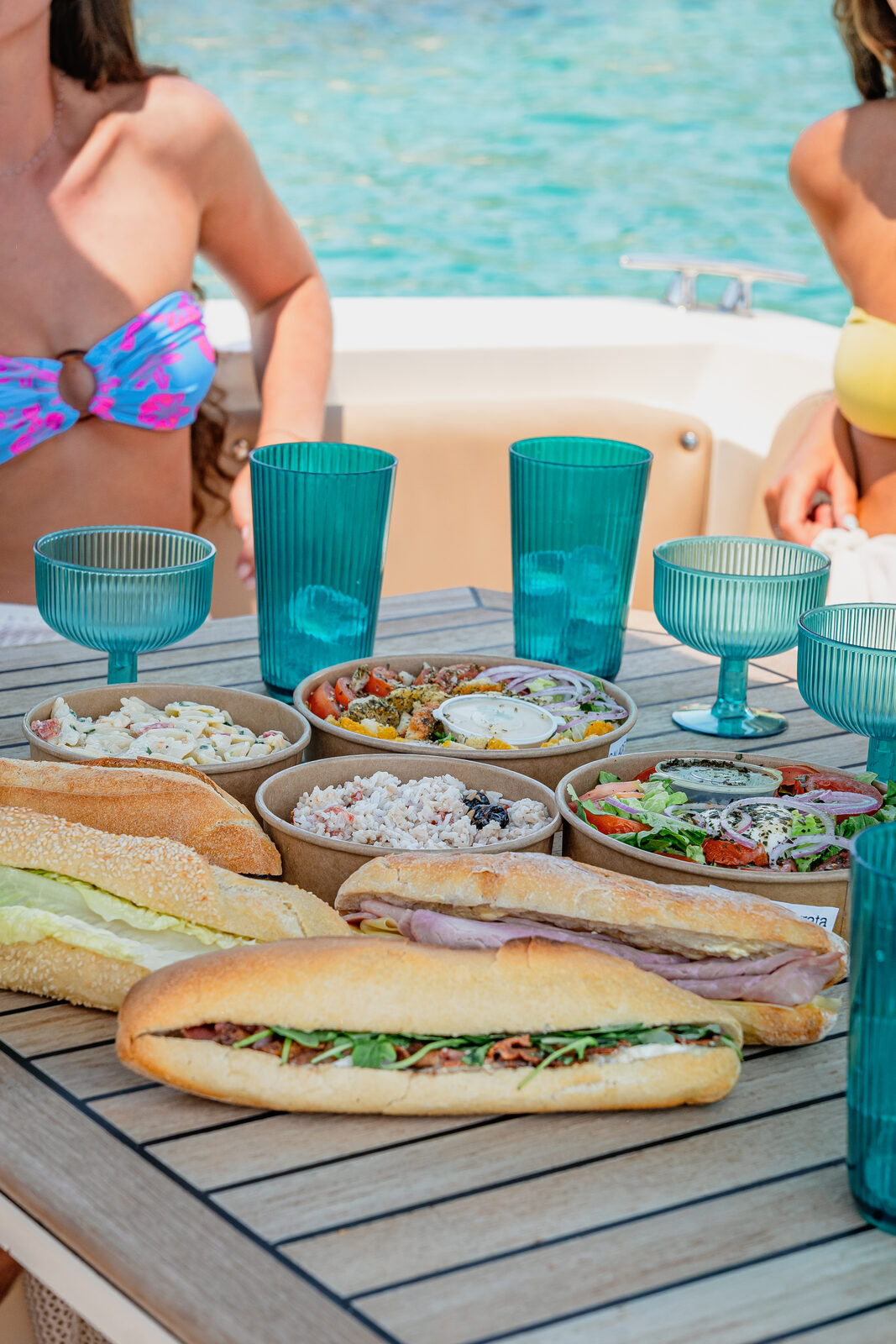 Paniers-repas Marinaloc sur la table du bateau : sandwichs, salades et boissons fraîches
